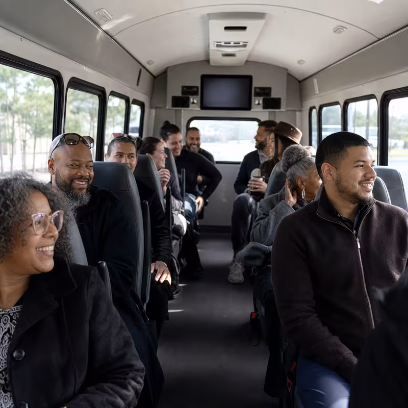 Group boarding a white charter bus for Private Event Transportation transportation in Dallas