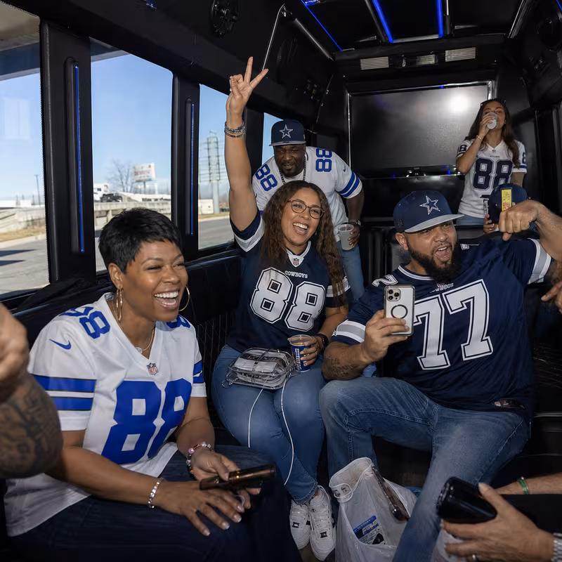 Group boarding a white charter bus for Sporting Event Transportation transportation in Dallas